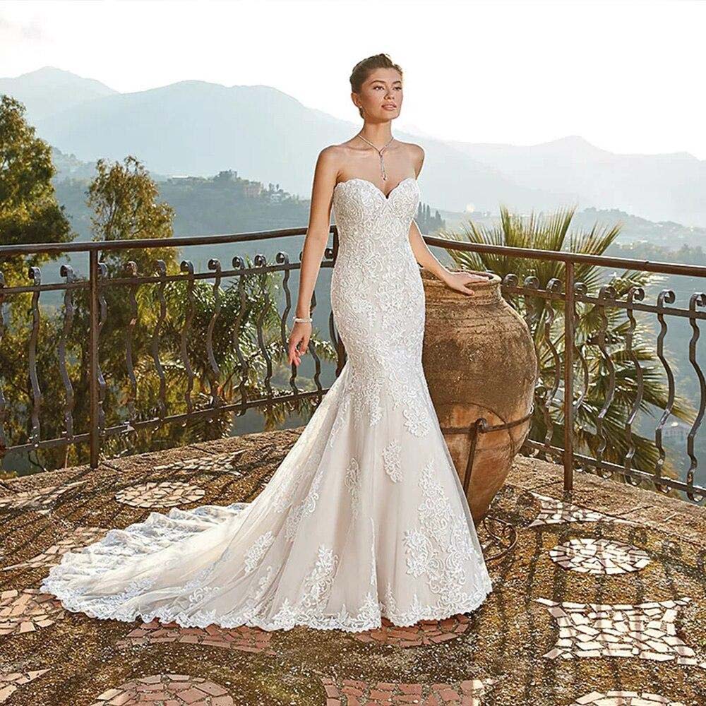 Side profile of a bride wearing a strapless mermaid wedding gown, highlighting the lace detailing and the stunning silhouette.