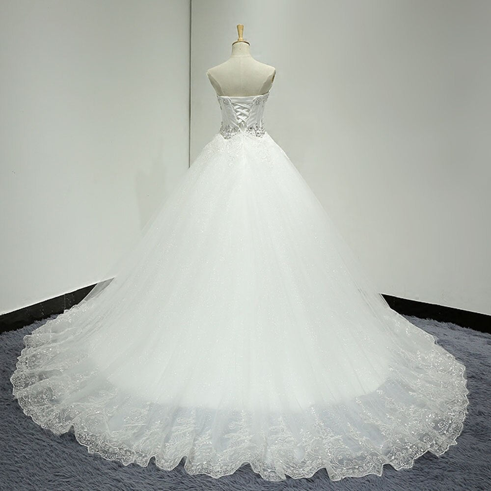 Rear view of a bridal mannequin showcasing the lace-up back design and full, voluminous tulle skirt of a beaded A-line wedding dress.