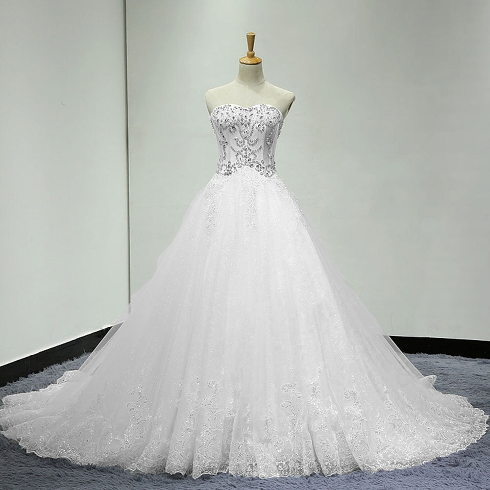 Full view of a mannequin wearing an A-line wedding gown with crystal sequin beading on the bodice and a sweeping skirt with detailed lace hem.