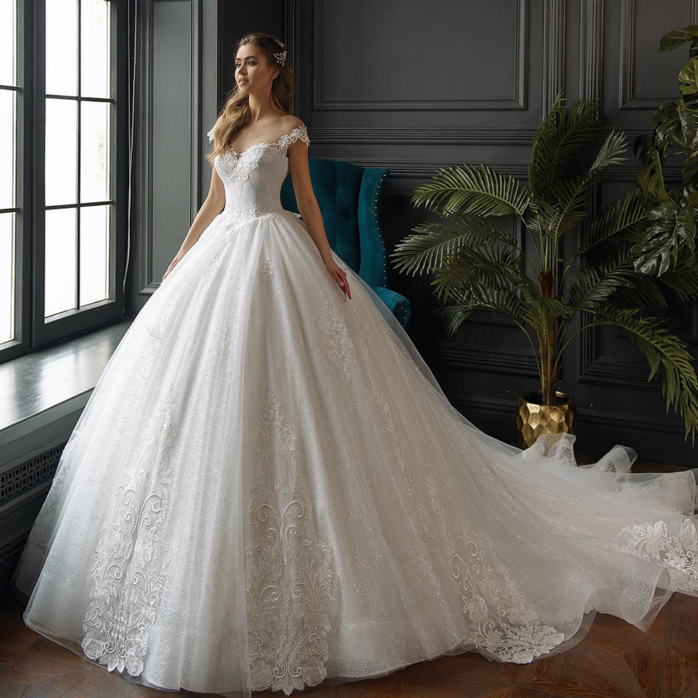 Beautiful bride standing in a luxurious gown, showcasing the silhouette of a shiny princess-style wedding dress.