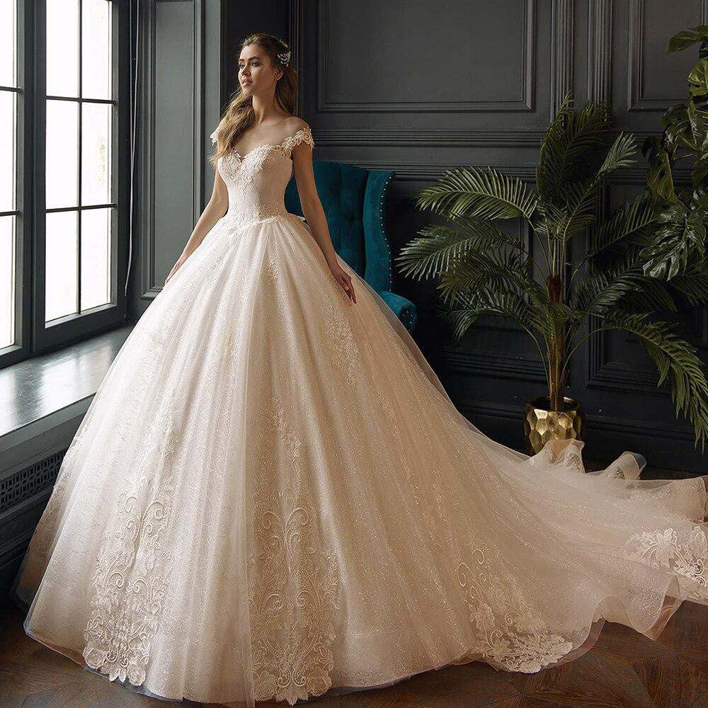 Side view of a bride wearing a shimmering princess ball gown, highlighting the elegant design and voluminous skirt.