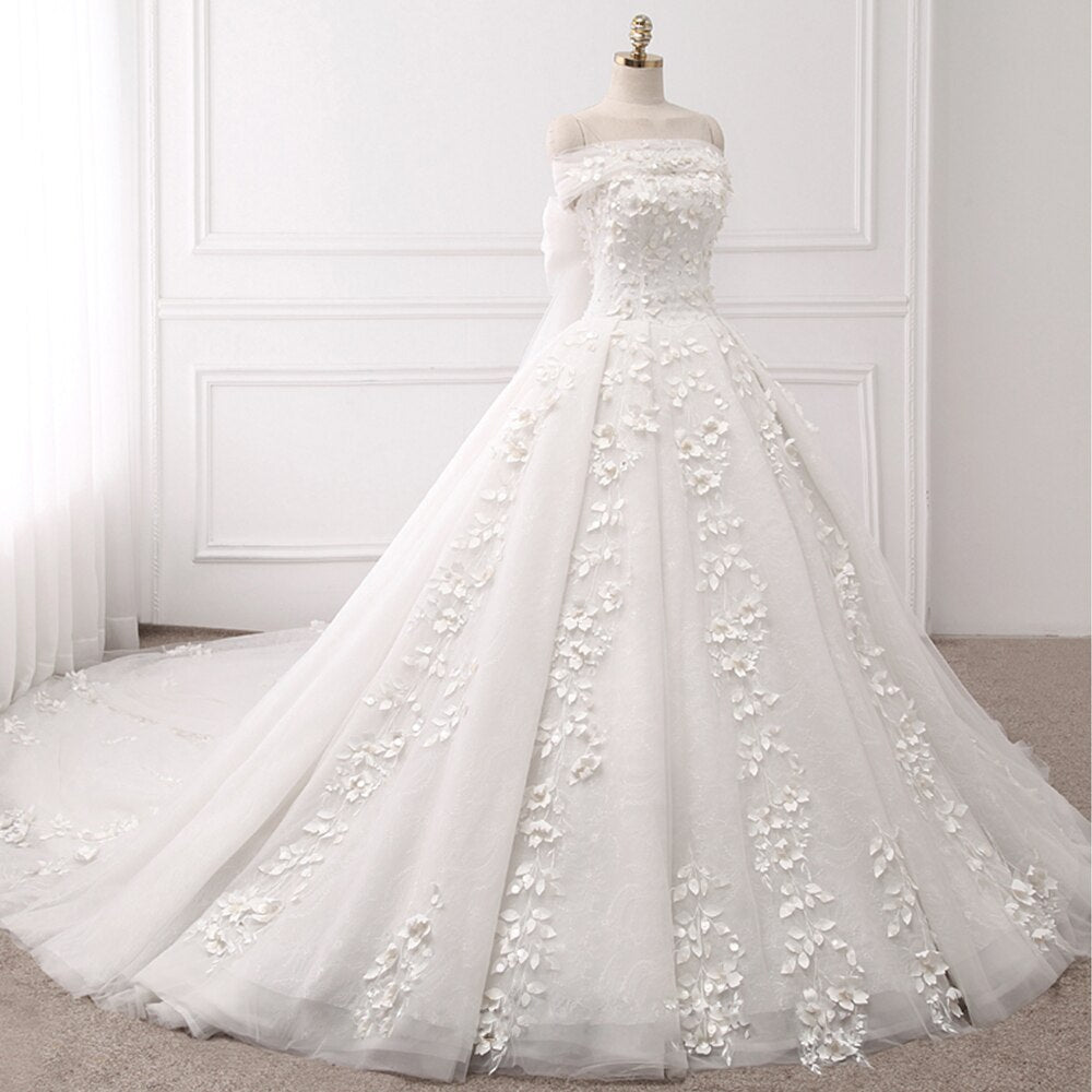 Full-length view of a princess ball gown wedding dress on a mannequin, highlighting the cascading 3D flower appliques and long train.