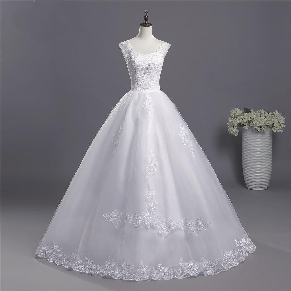 Full-length view of an elegant white A-line wedding dress with delicate lace appliqués on a mannequin.